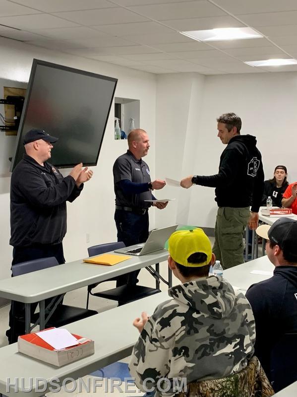 Firefighter Michael "Adam" Finden being presented his certification by New York State Fire Instructor Daniel Hickey Jr., who is also a City of Hudson Firefighter and past Captain.